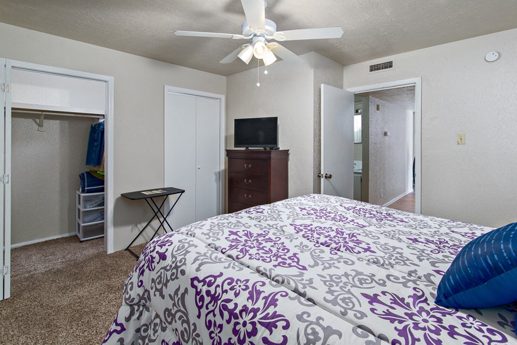 a bedroom with a large bed and a ceiling fan