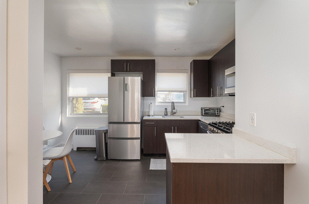 a view of a kitchen with a table and a refrigerator