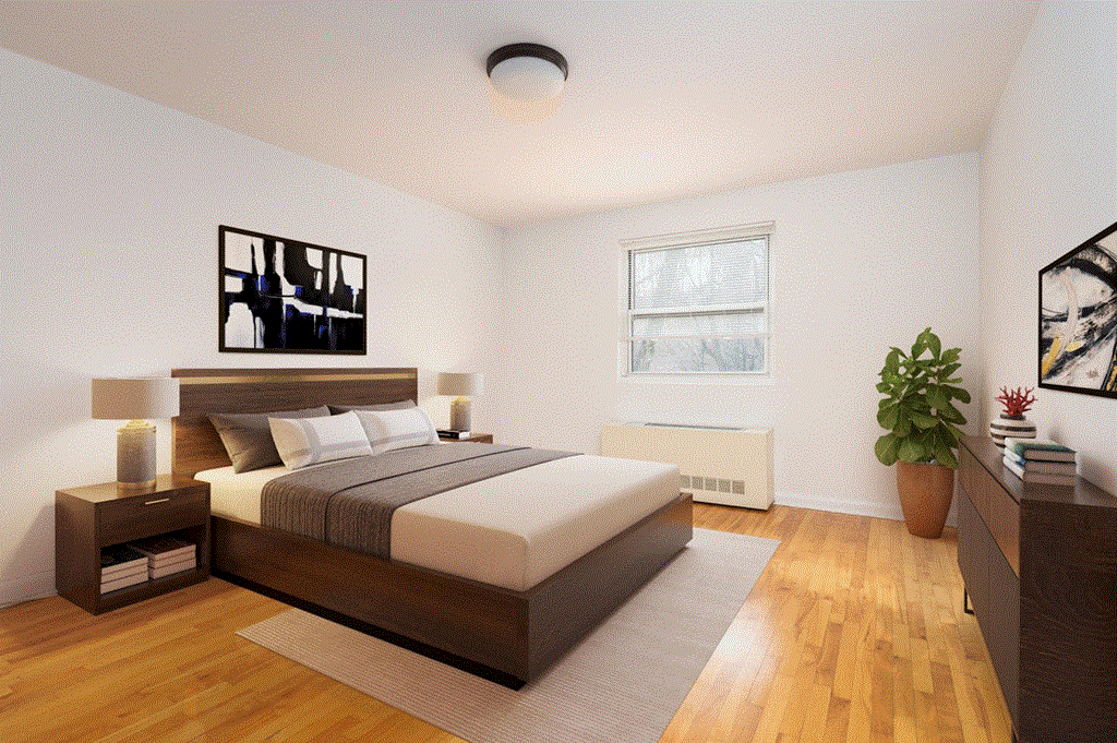 a bedroom with white walls and wood floors and a bed