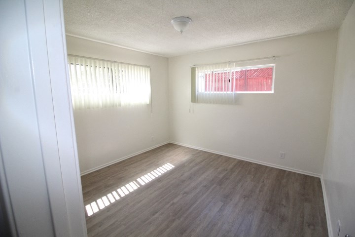 an empty room with wooden floors and a window