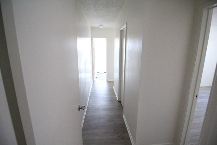a view down a hallway with white walls and white doors
