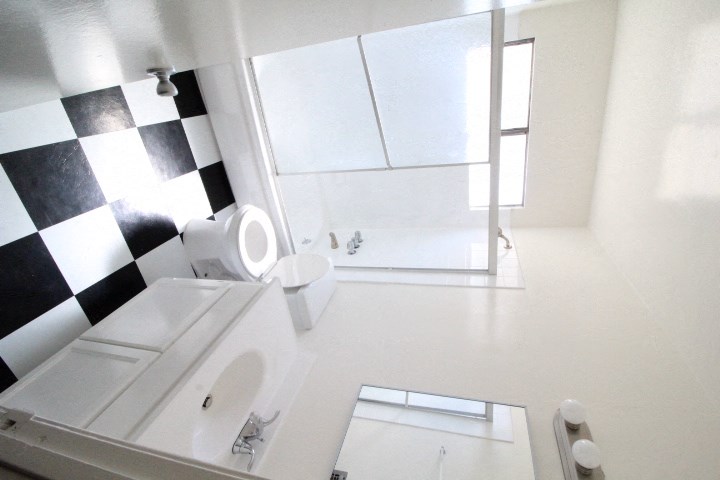 a white bathroom with a black and white checkered wall