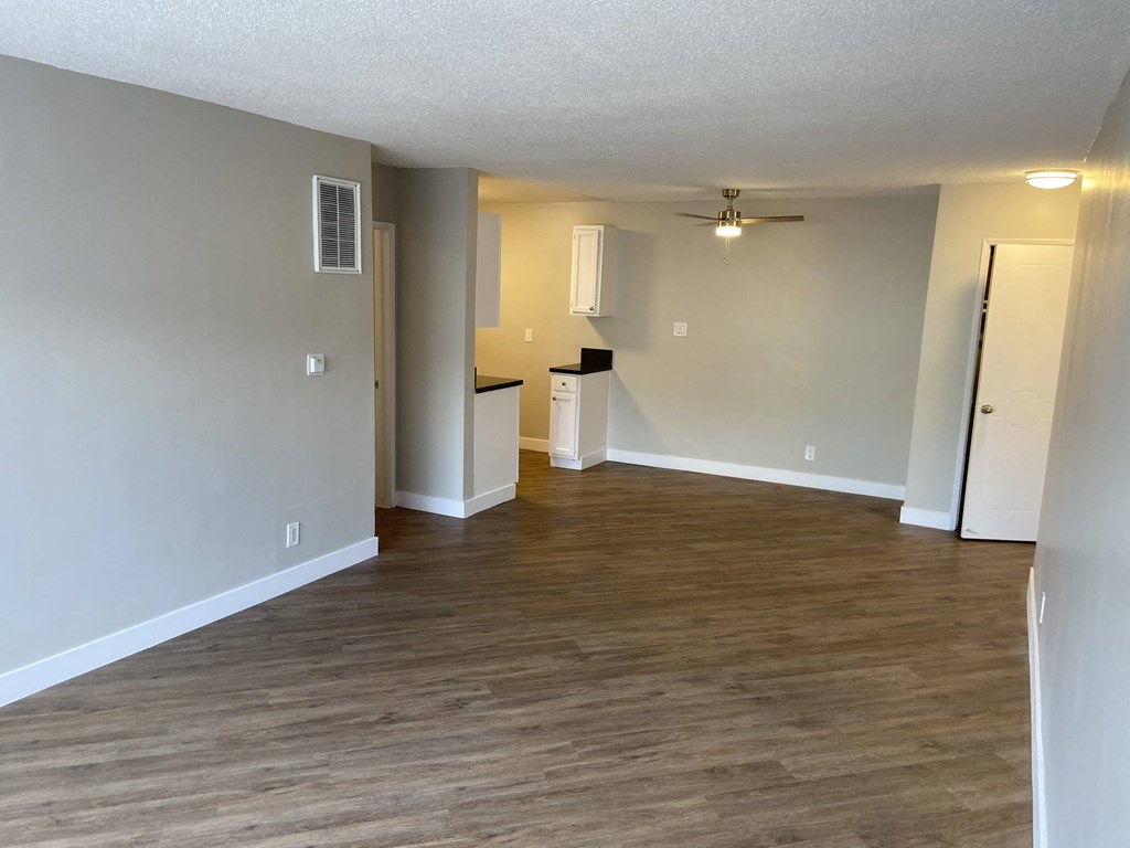 a living room with a wood floor and a ceiling fan