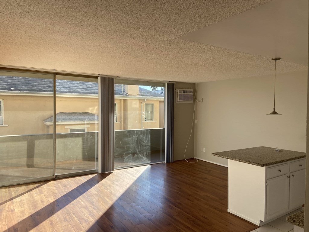 an empty living room with sliding glass doors to a balcony