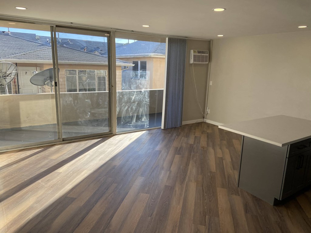 a living room with wood floors and a large window
