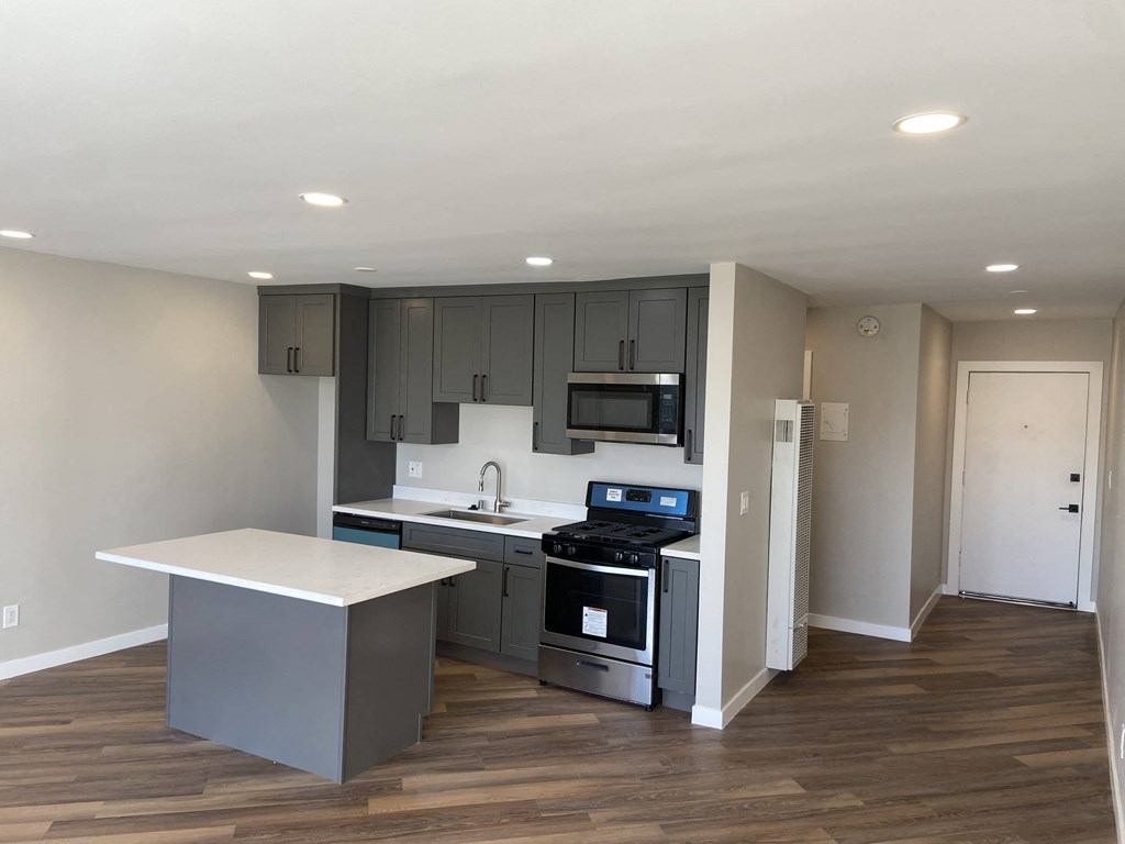 a kitchen with gray cabinets and a white counter top