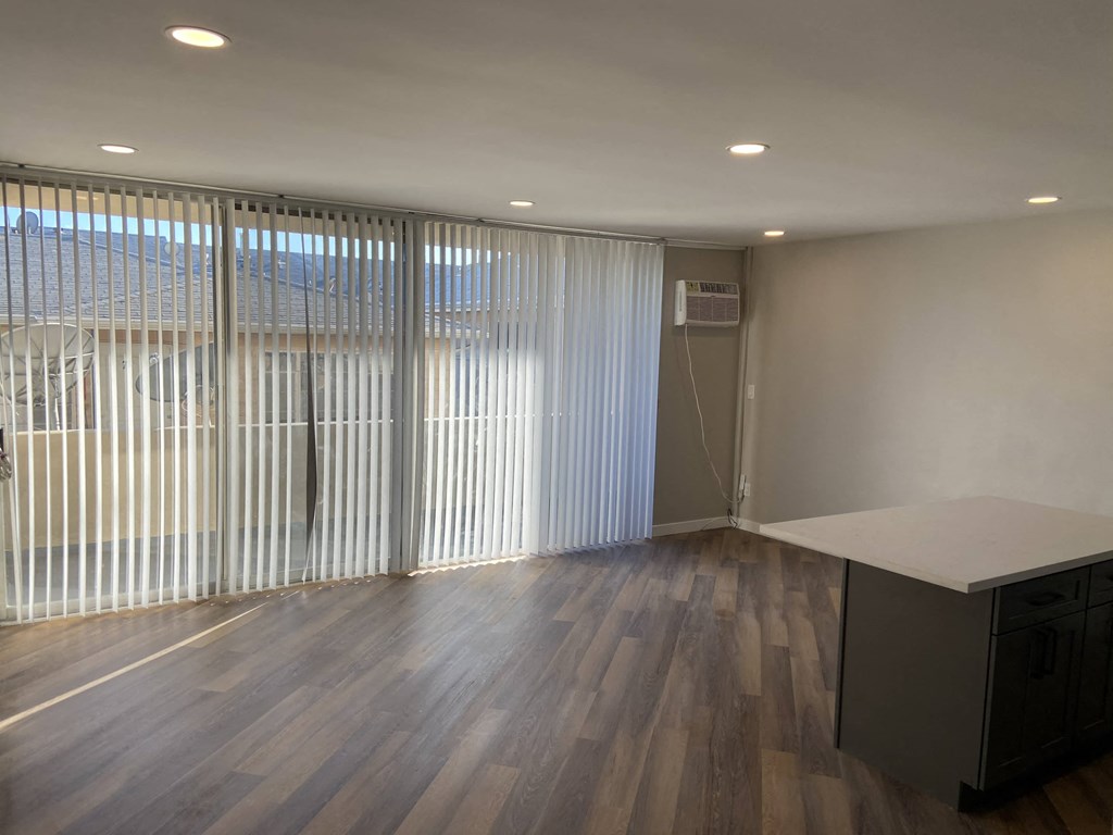 an empty living room with blinds on the window