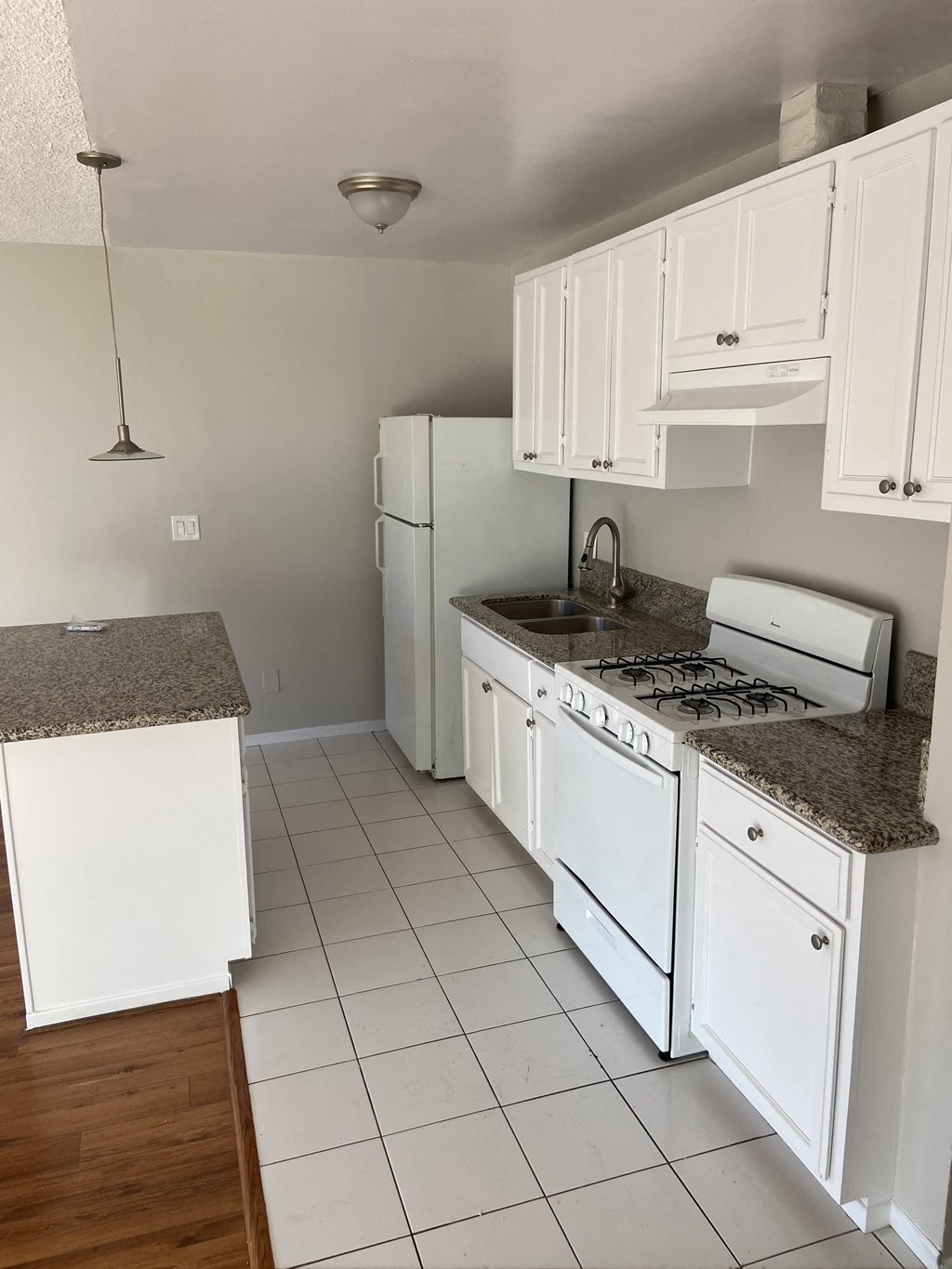 a kitchen with white cabinets and a stove and a refrigerator