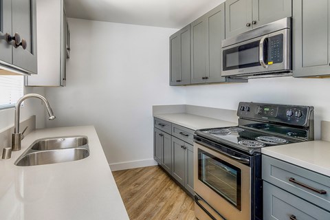a kitchen with stainless steel appliances and white counter tops