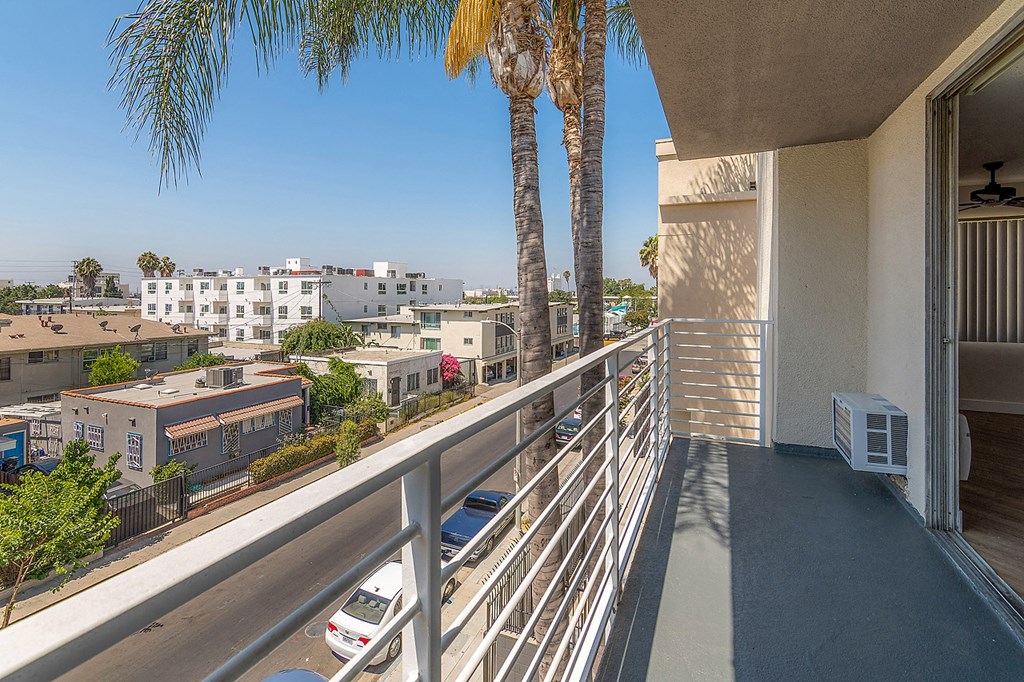 a balcony with a view of the city and palm trees