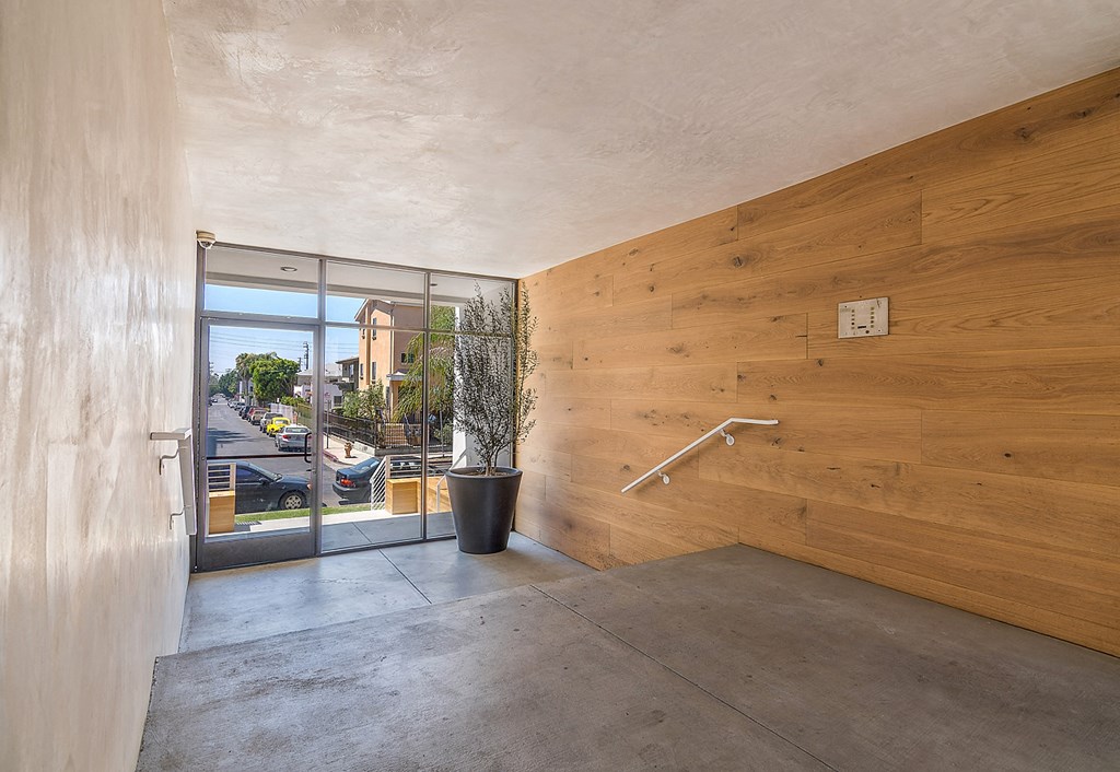 a hallway with a wooden wall and a glass door and a staircase