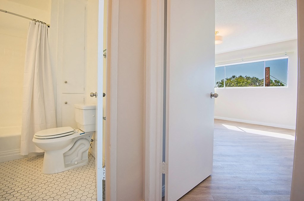 a bathroom with a toilet and a white shower curtain