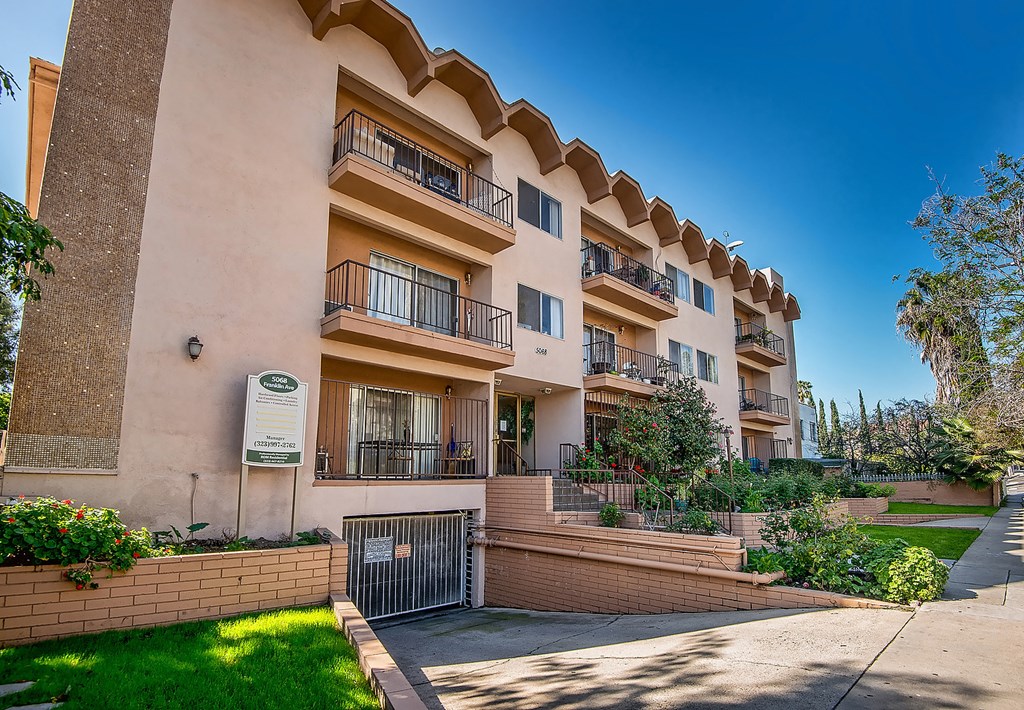 an apartment building with balconies and a sidewalk