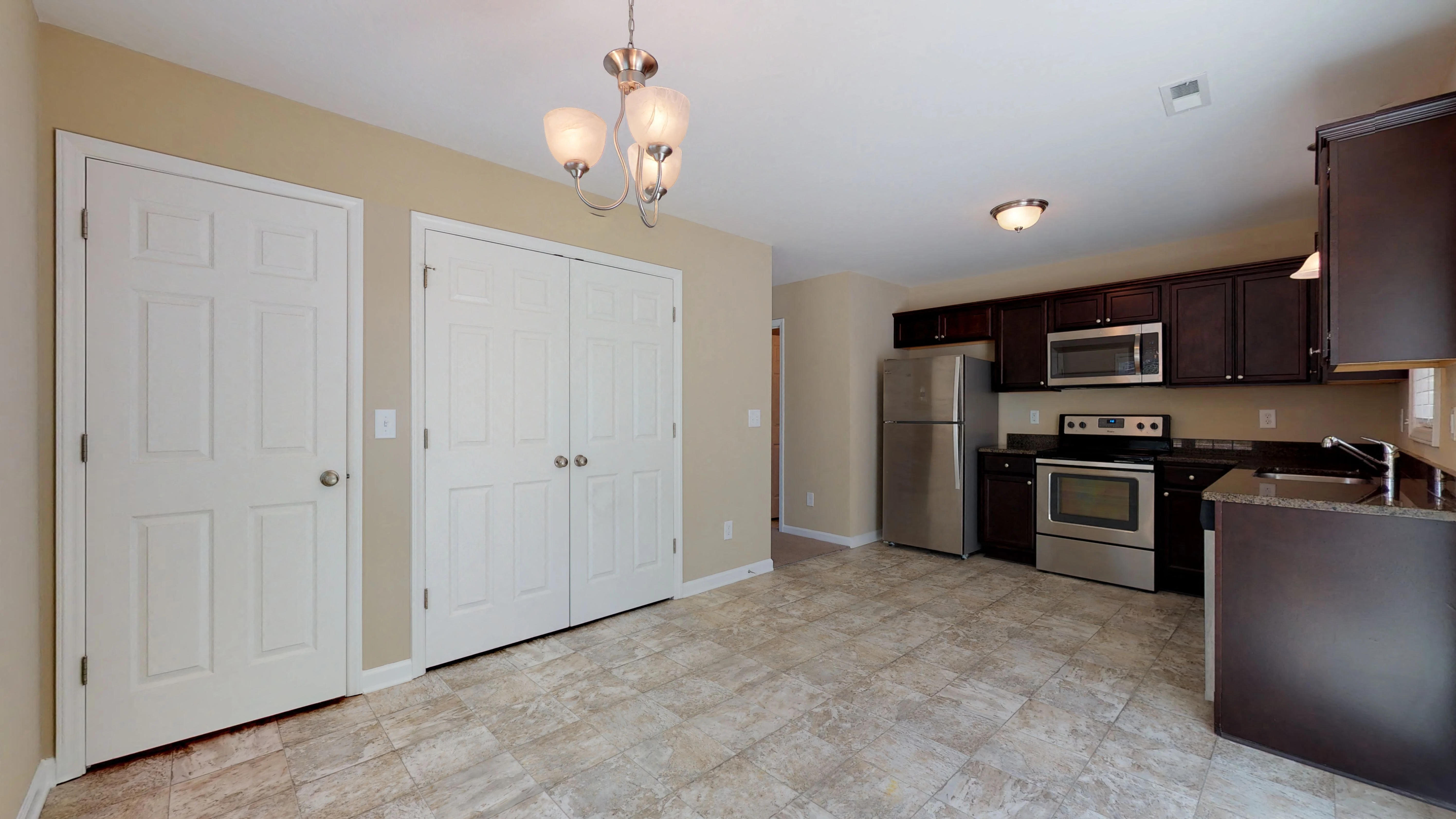 a kitchen with stainless steel appliances and white doors