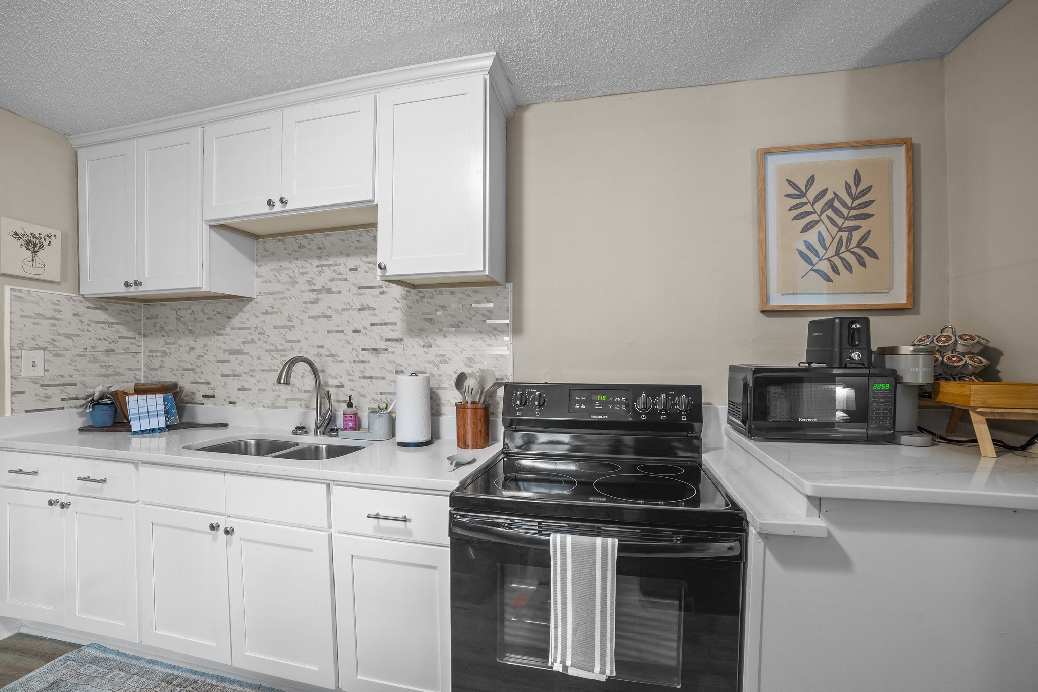 a kitchen with white cabinets and a black stove