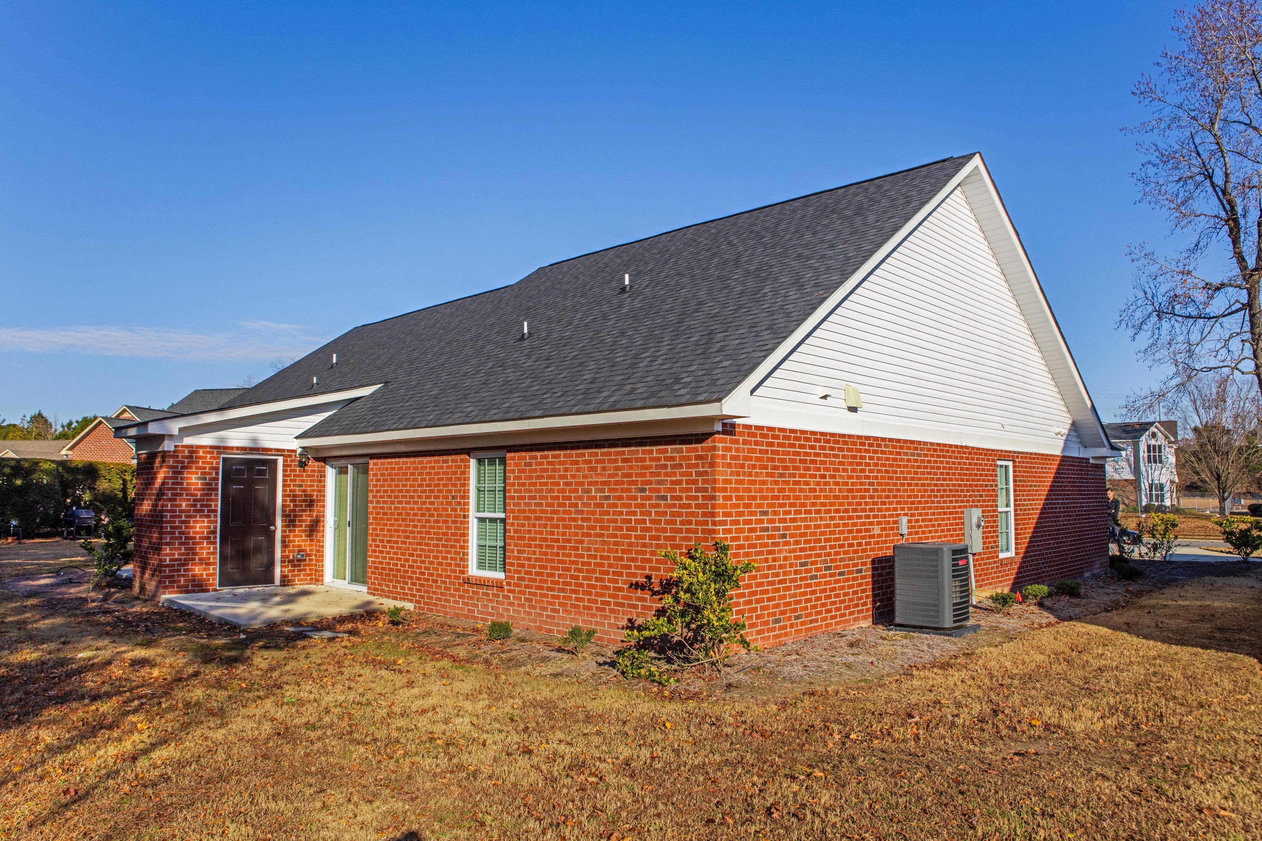 the front of a brick house with a grey roof