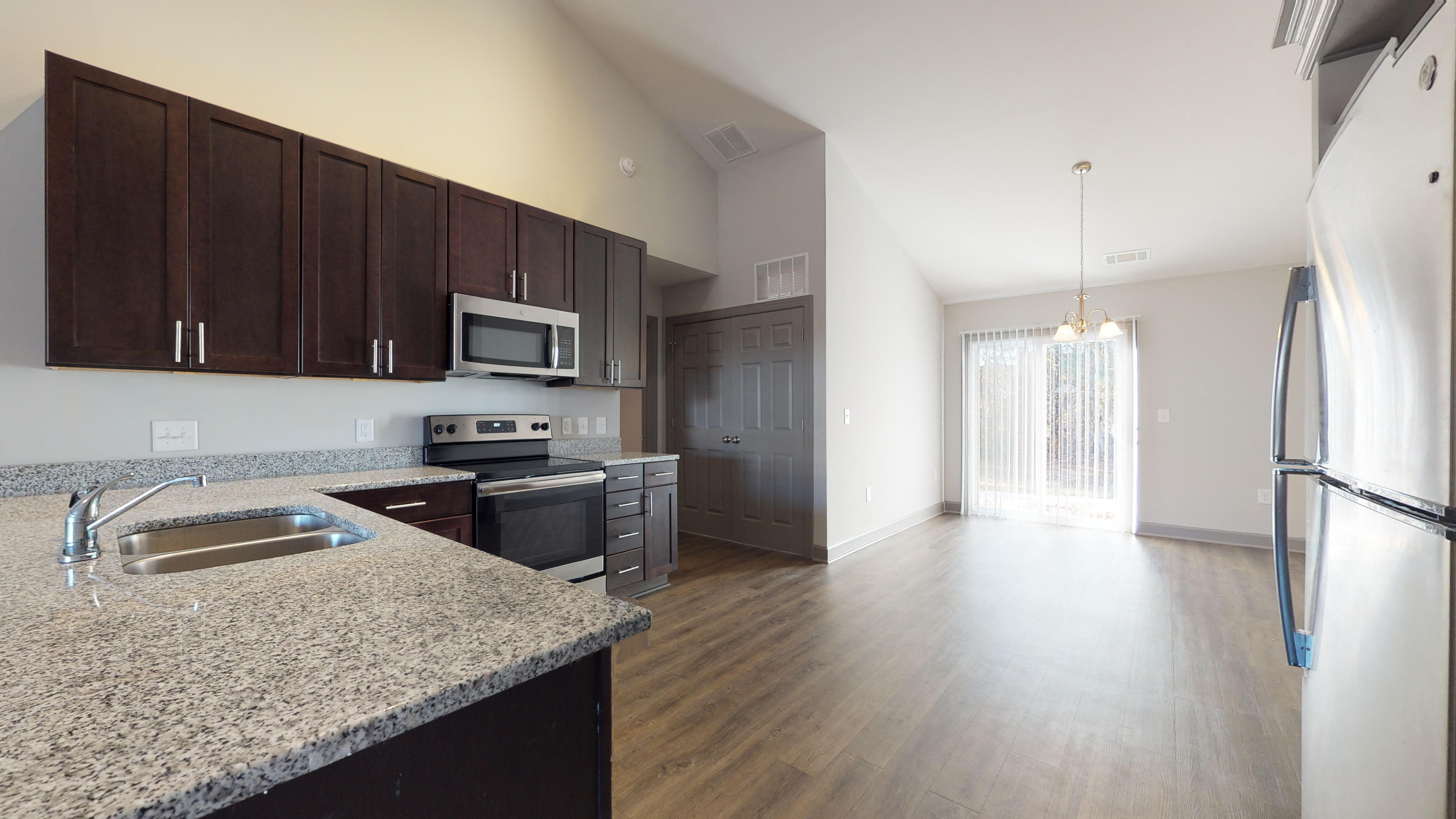 an empty kitchen with granite counter tops and stainless steel appliances