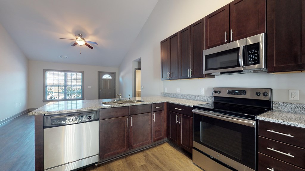 an empty kitchen with wooden cabinets and stainless steel appliances