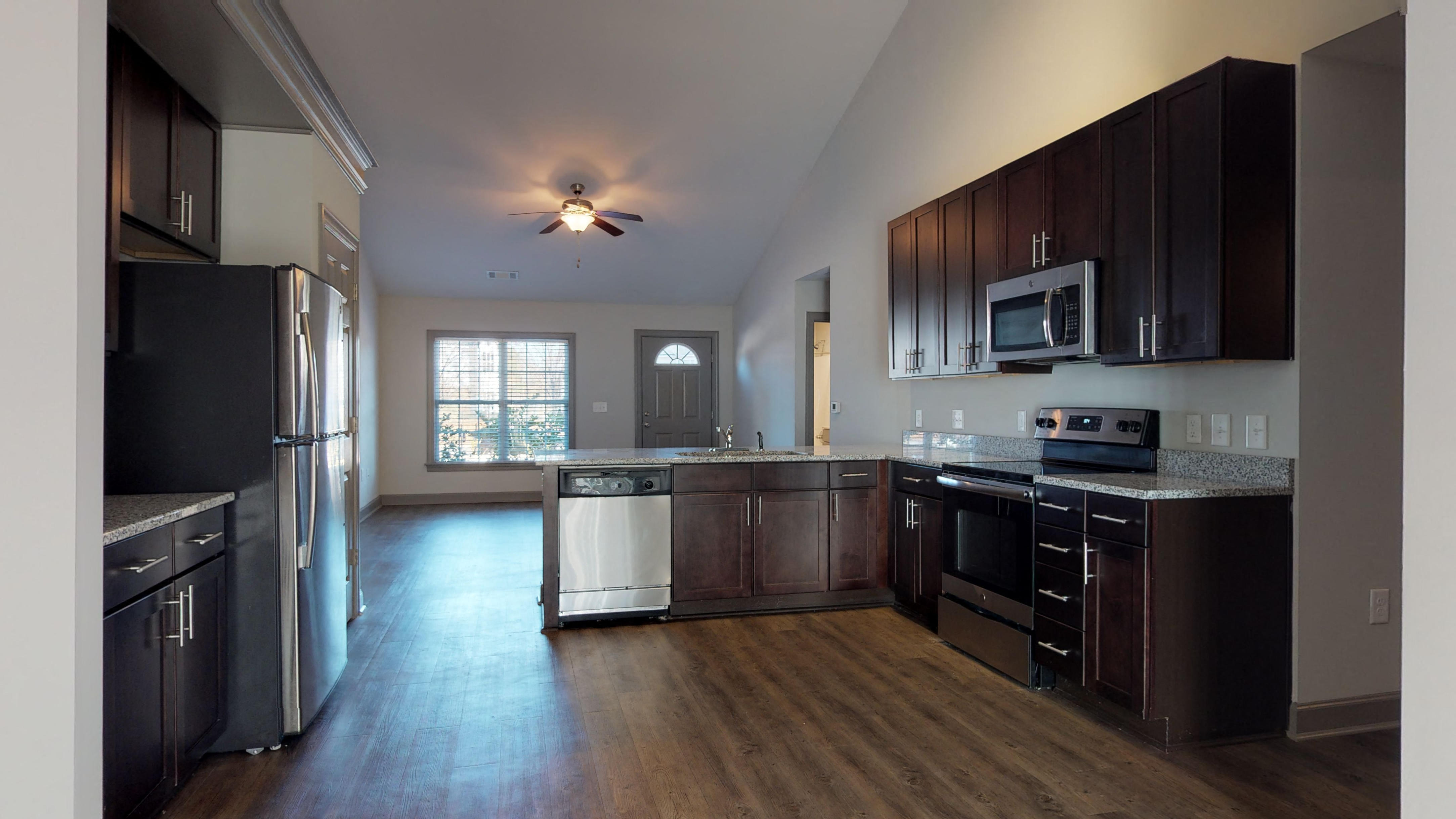an empty kitchen with wooden cabinets and stainless steel appliances