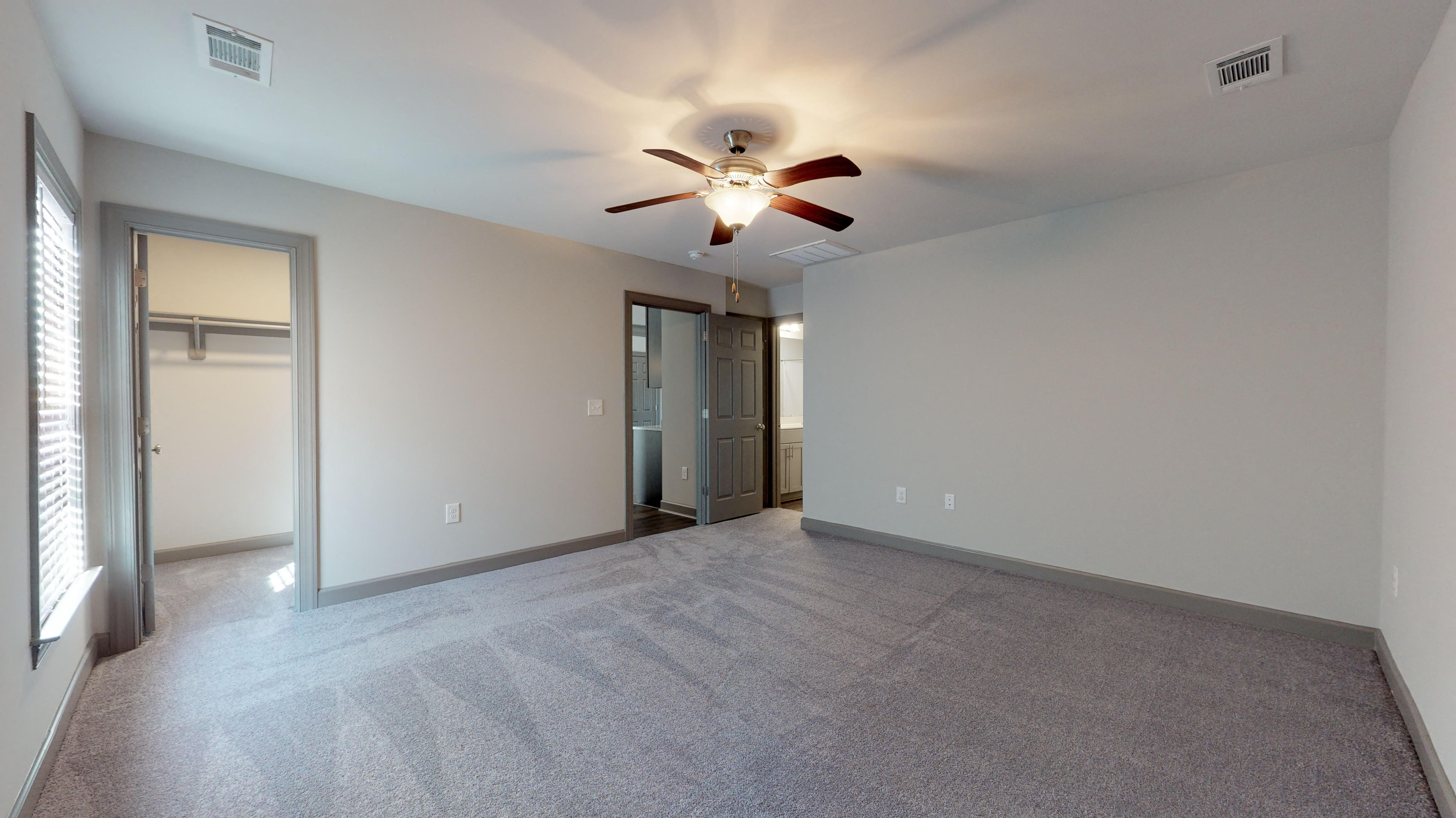 the spacious living room with ceiling fan in a new home
