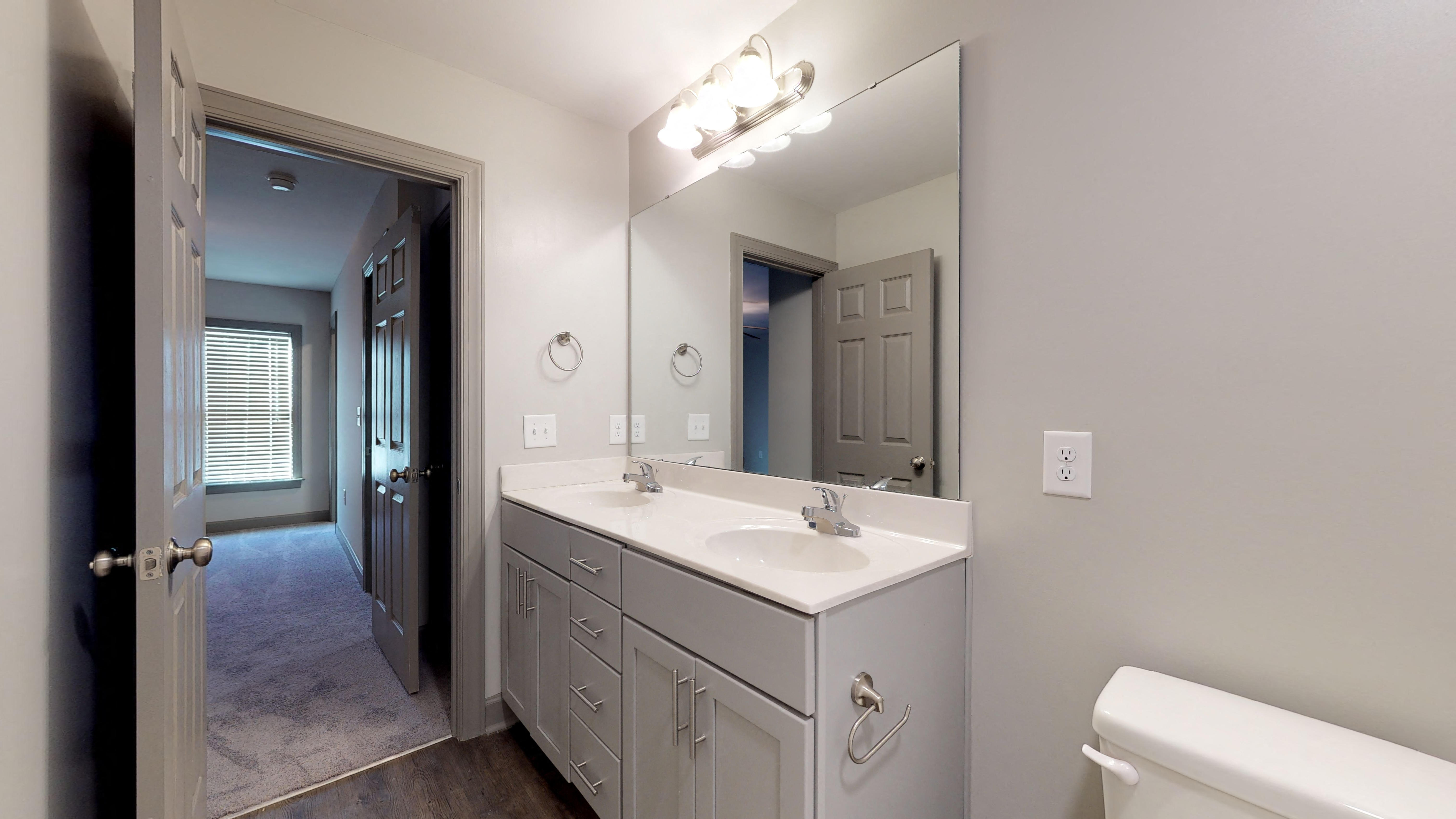 a bathroom with a large mirror and a toilet and sink