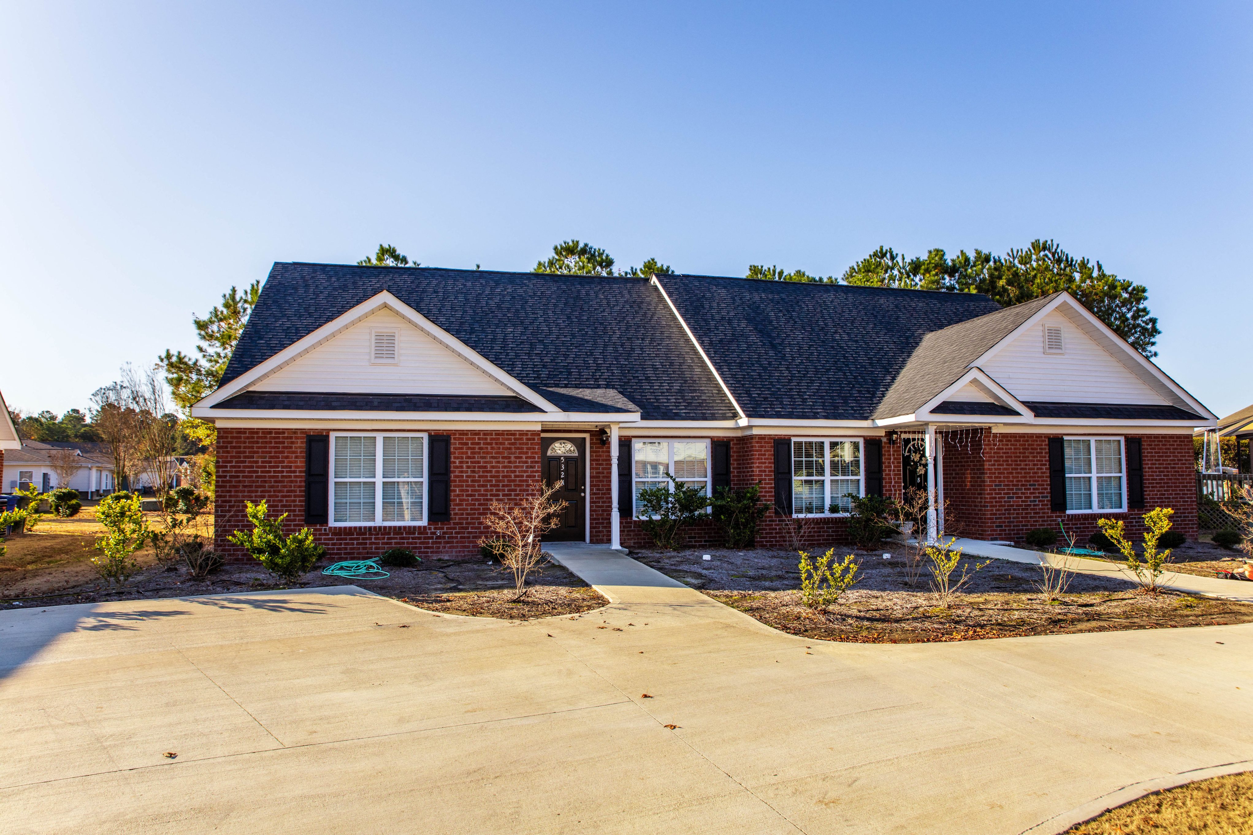 a red brick house with a driveway in front of it