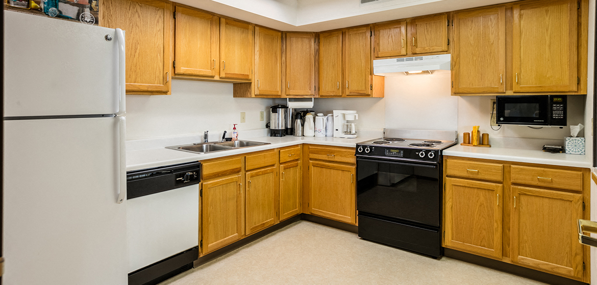 a kitchen with black and white appliances and wooden cabinets