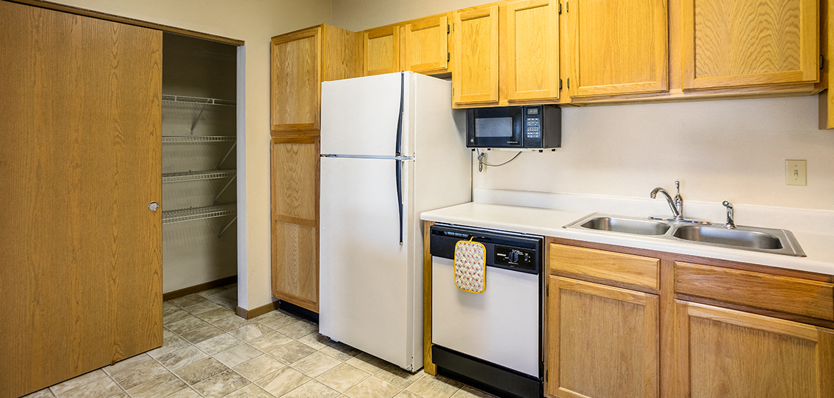 a kitchen with a white refrigerator and a sink