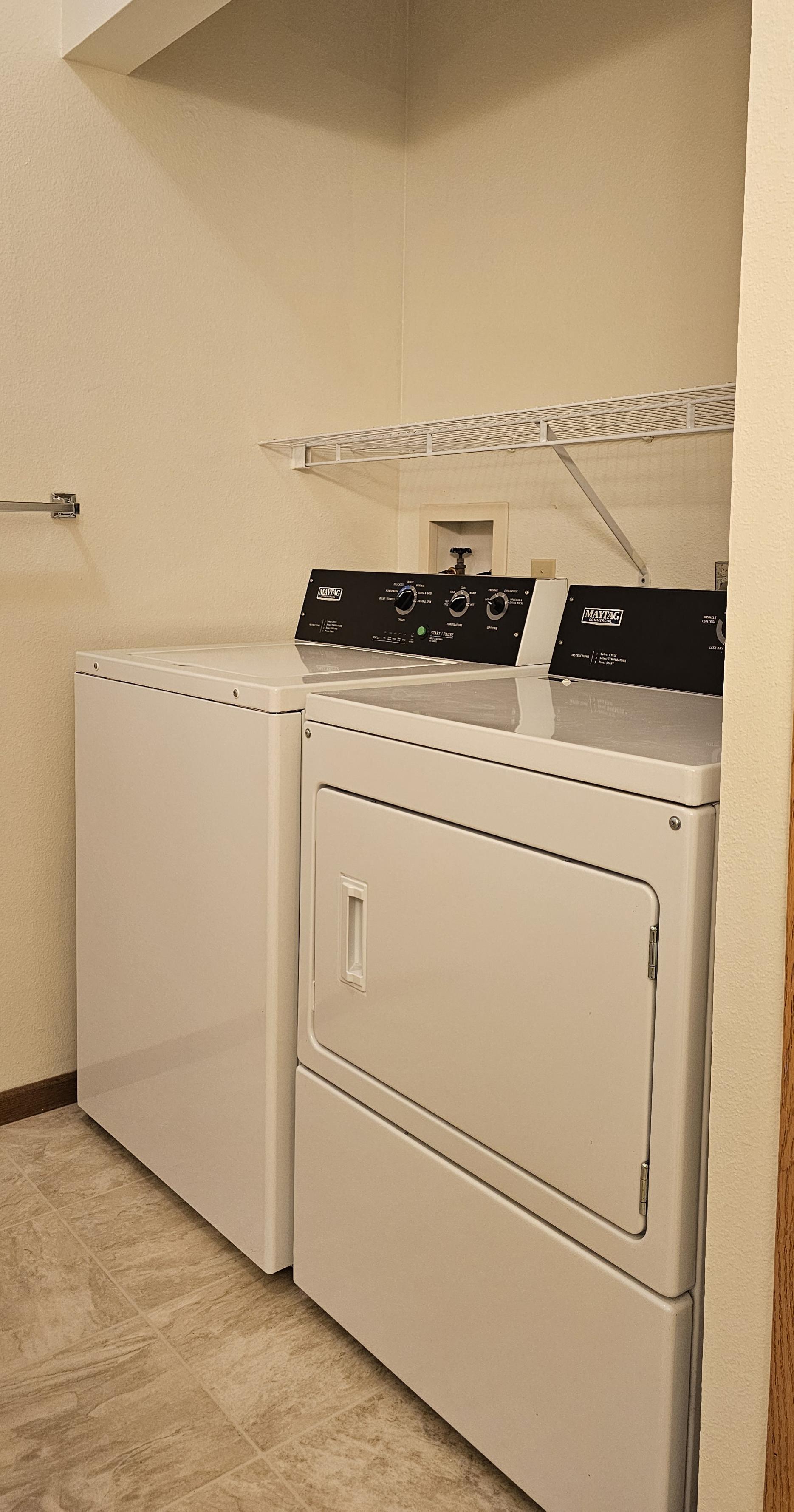 A white washing machine and dryer in a laundry room.