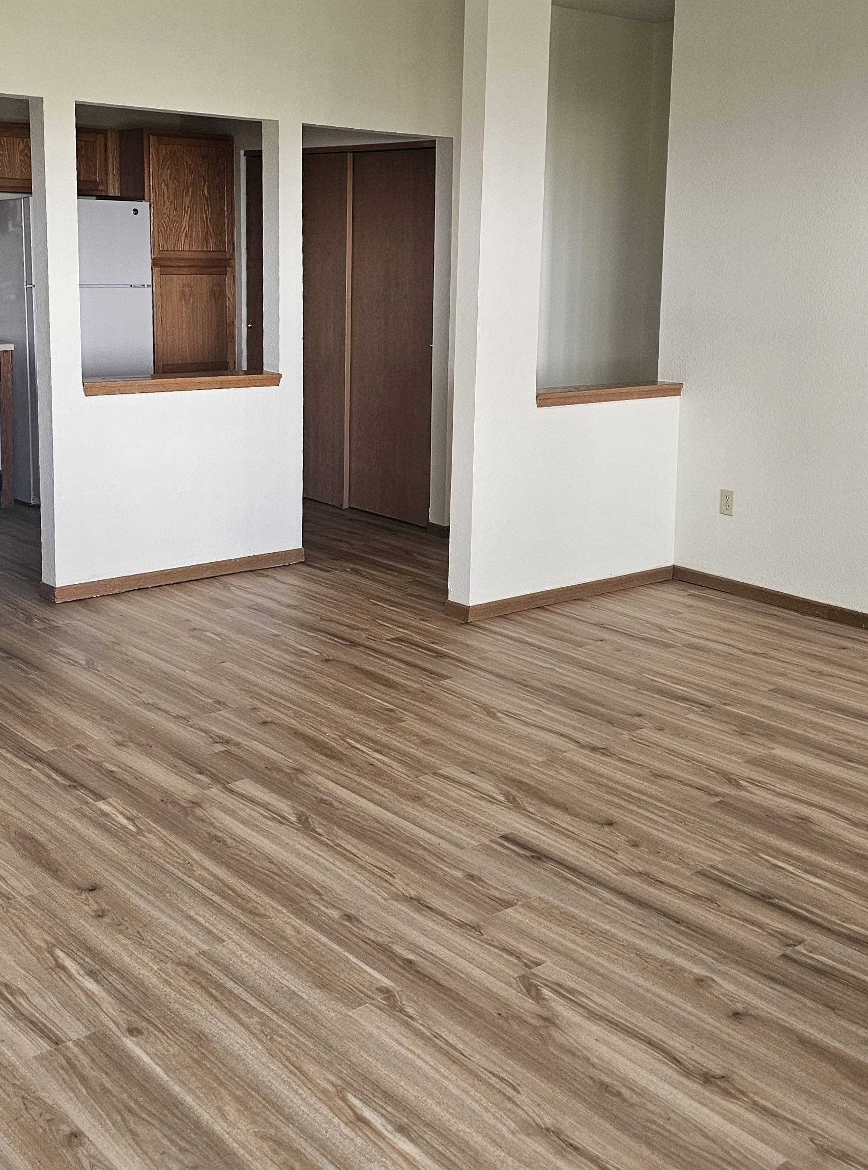 A room with wooden flooring and white walls.