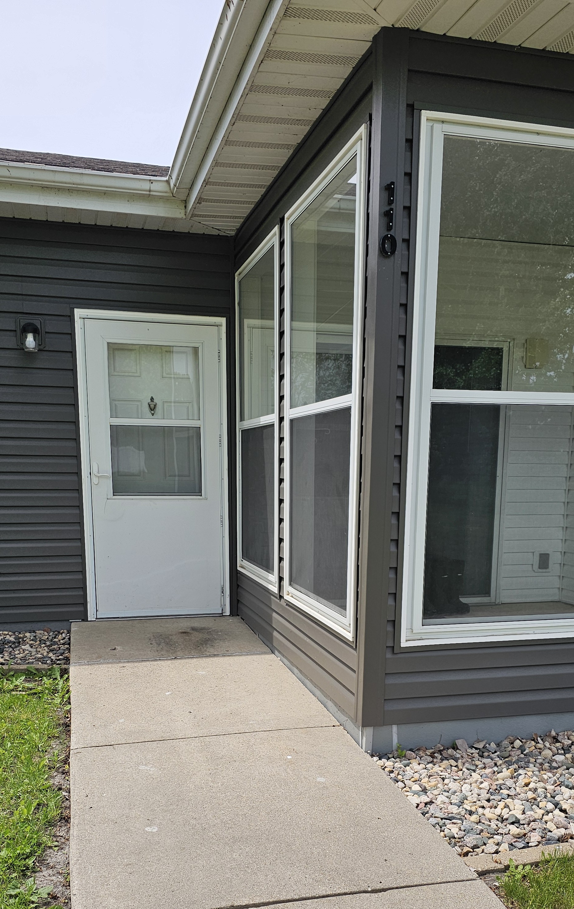 A grey house with a white door and windows.