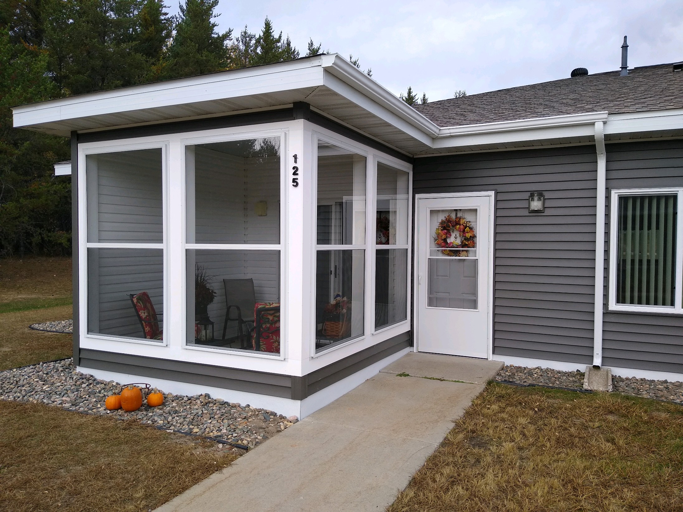 the front of a grey house with a porch