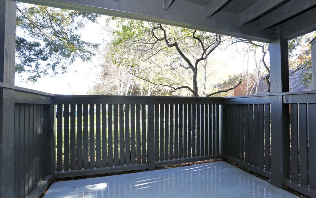 a screened porch with a view of the trees