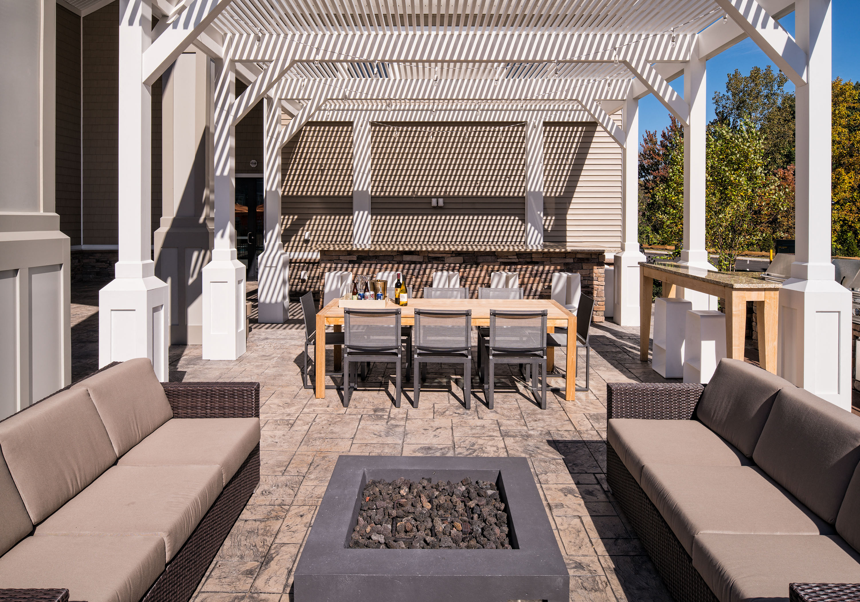 a large patio with a table and chairs and a fire pit