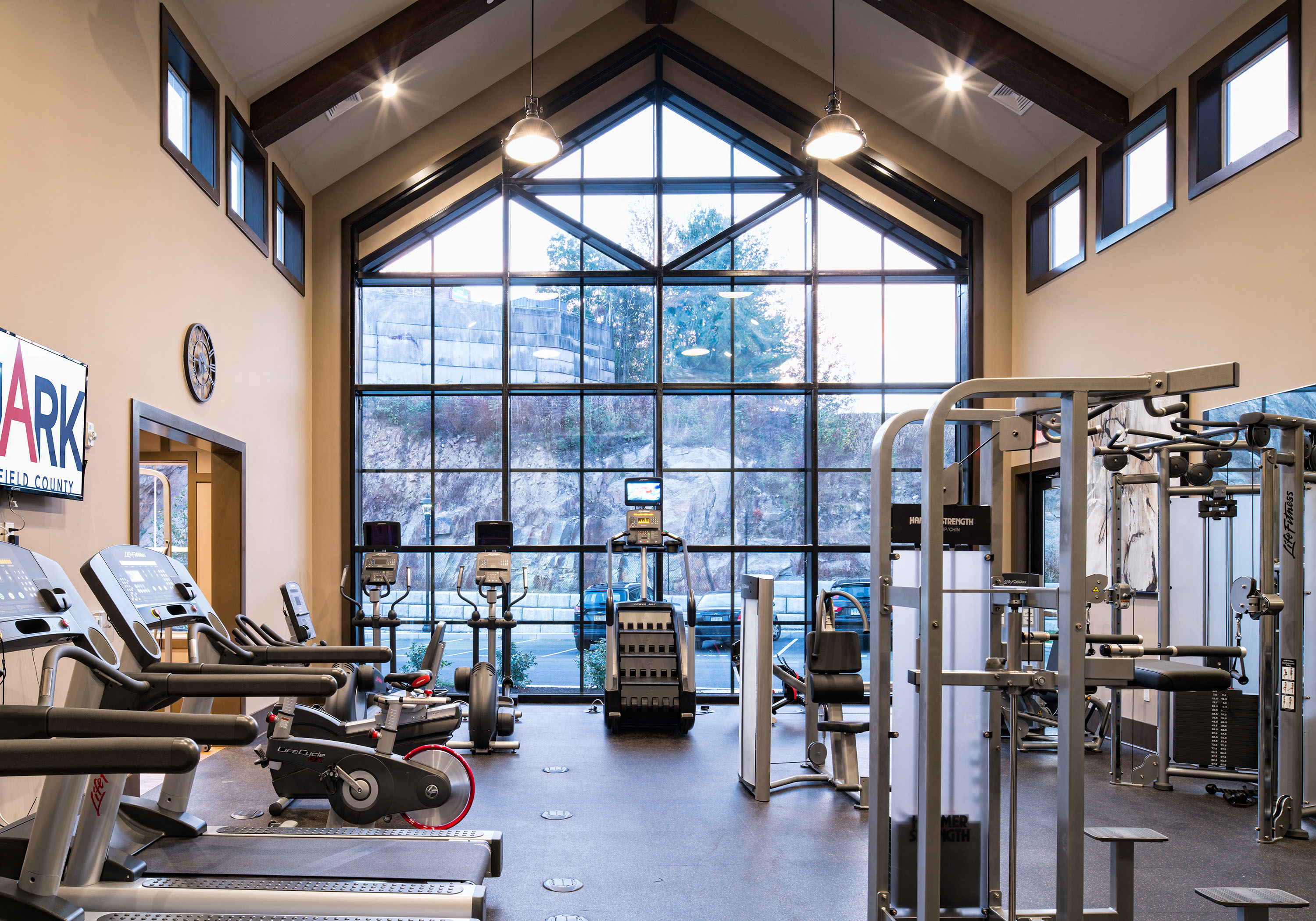 a gym with weights machines and a large window