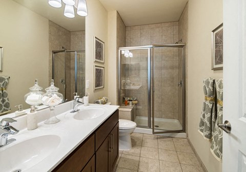 a bathroom with two sinks and a shower