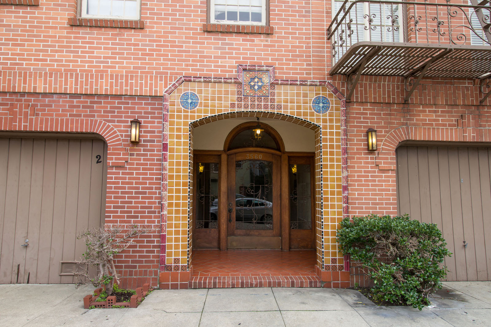 A red brick building with a wooden door and windows.
