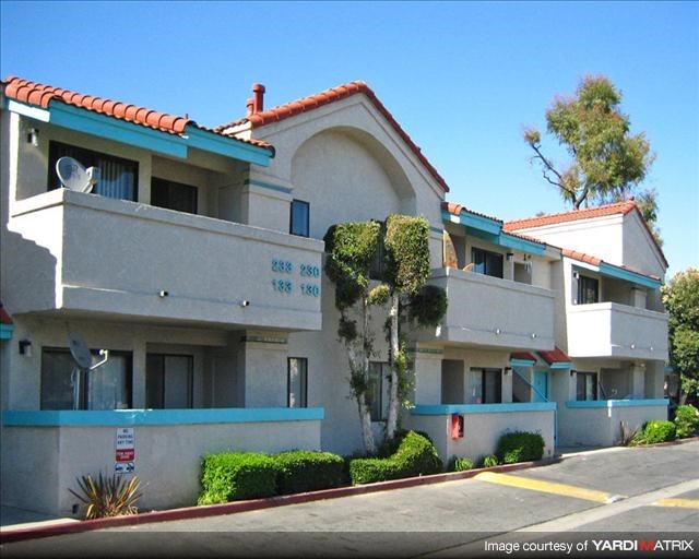 a white apartment building with blue and white balconies