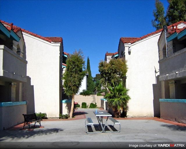 a table and chairs in a courtyard between two buildings