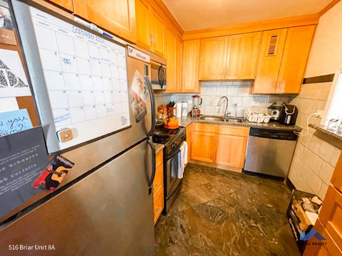 a kitchen with a refrigerator and a calendar on the wall