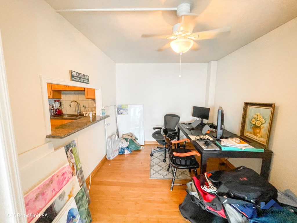 a cluttered room with a desk and a computer