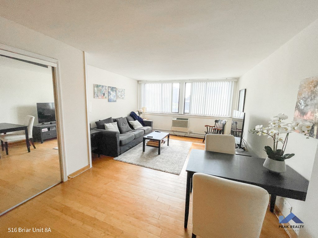 an image of a living room and dining room with wood floors