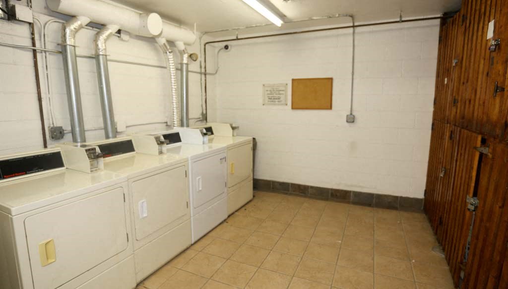 a laundry room with several sinks and white appliances