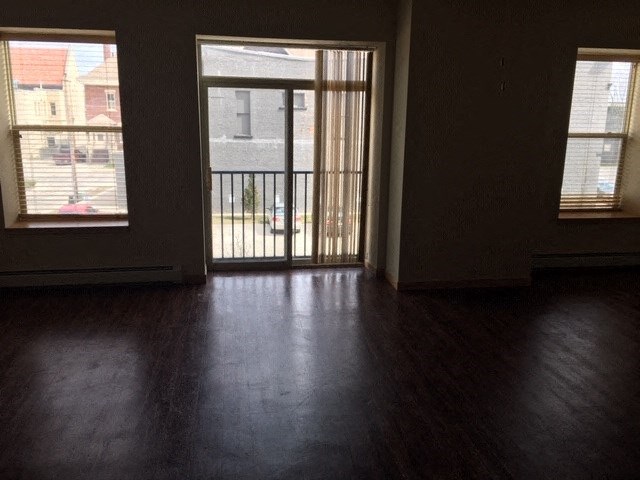 an empty living room with a door to a balcony