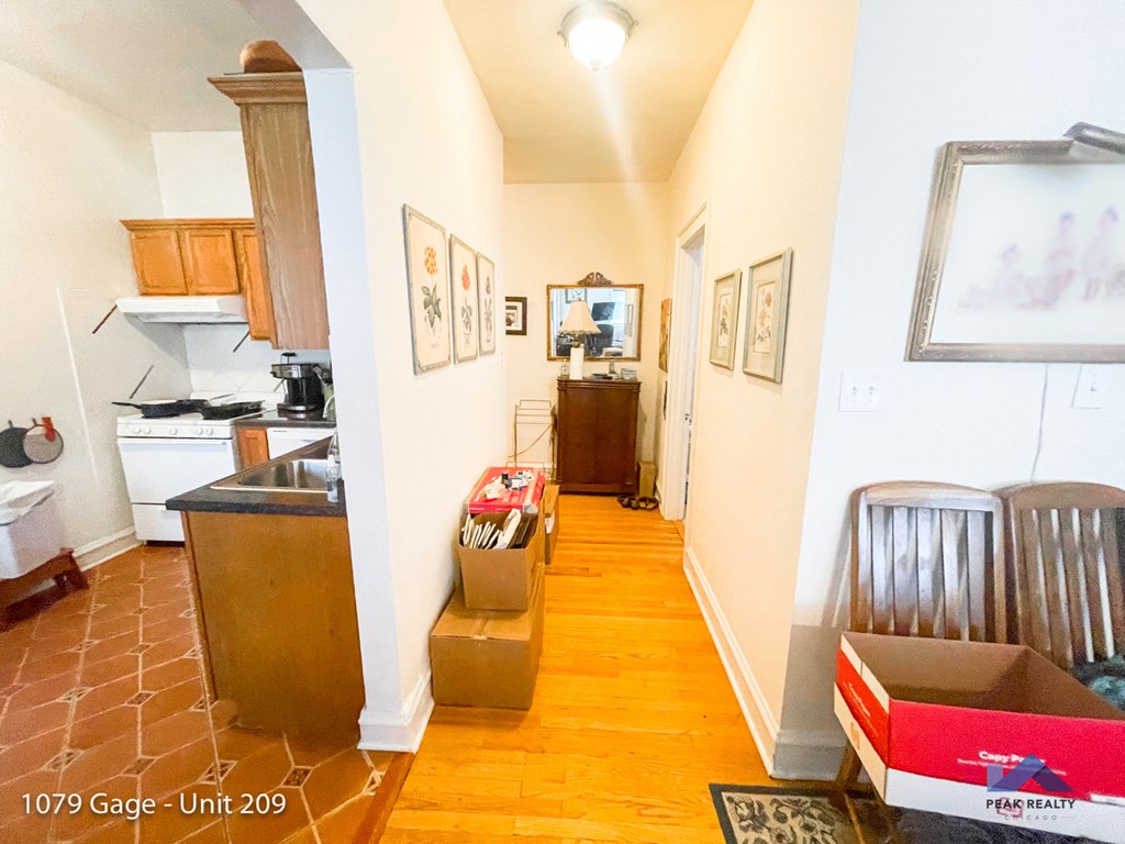 a living room and kitchen with boxes on the floor