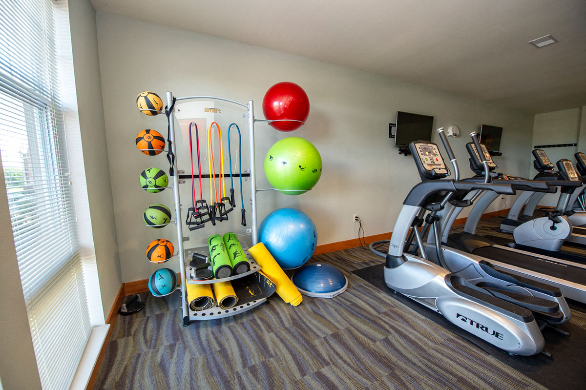 a gym with a treadmill and other exercise equipment in a room
