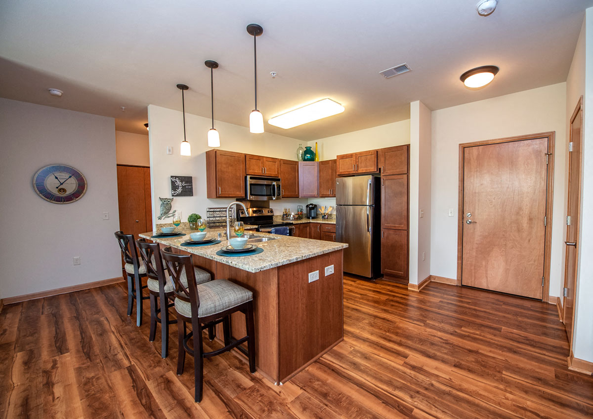 a kitchen with a center island and a stainless steel refrigerator