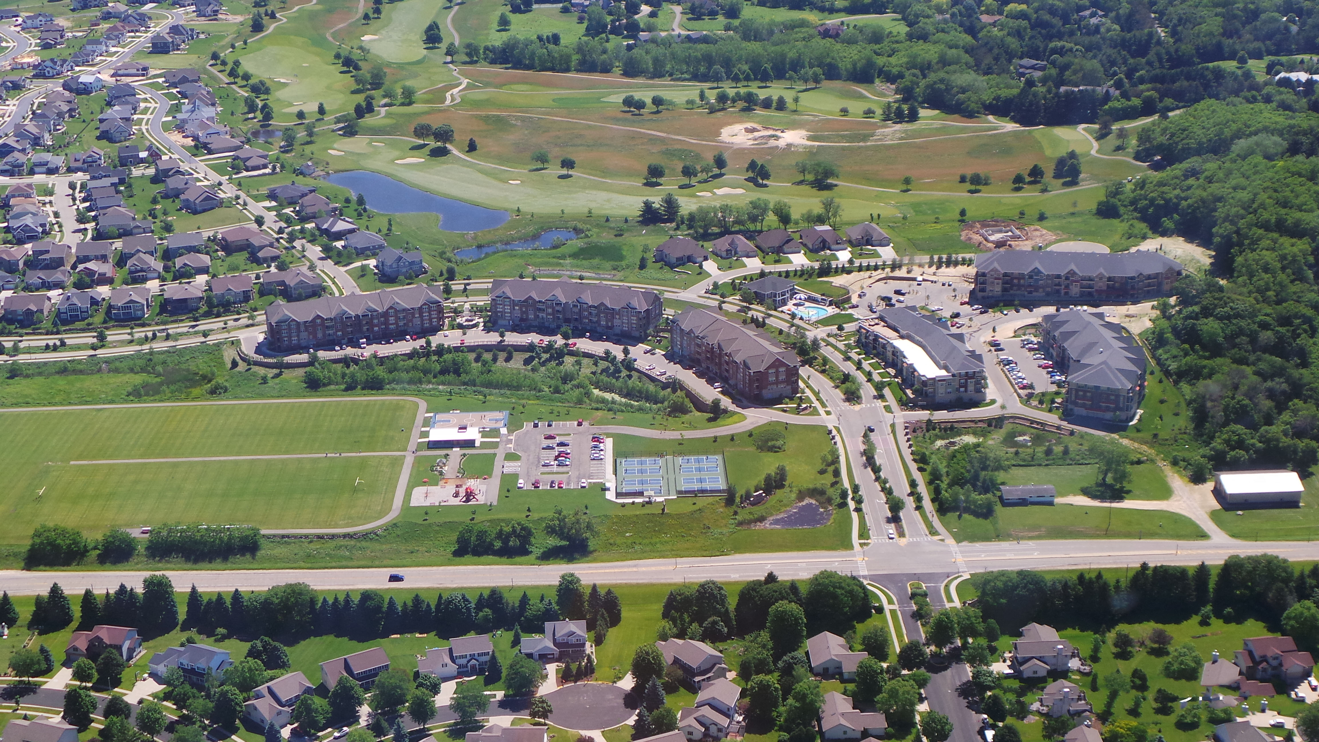 an aerial view of a city with houses and a golf course