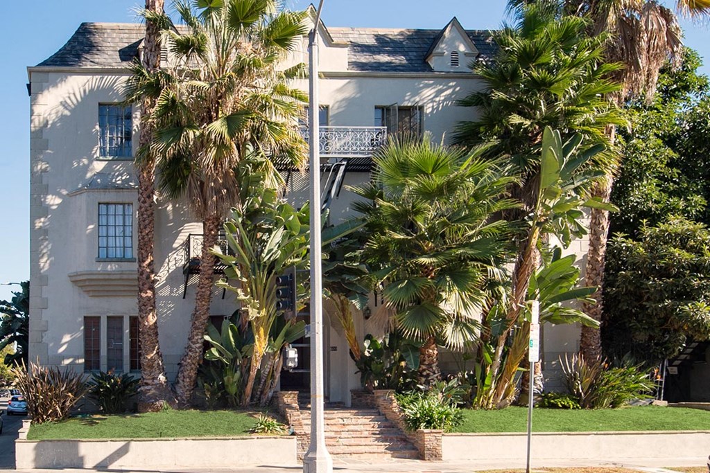 a white house with palm trees in front of it