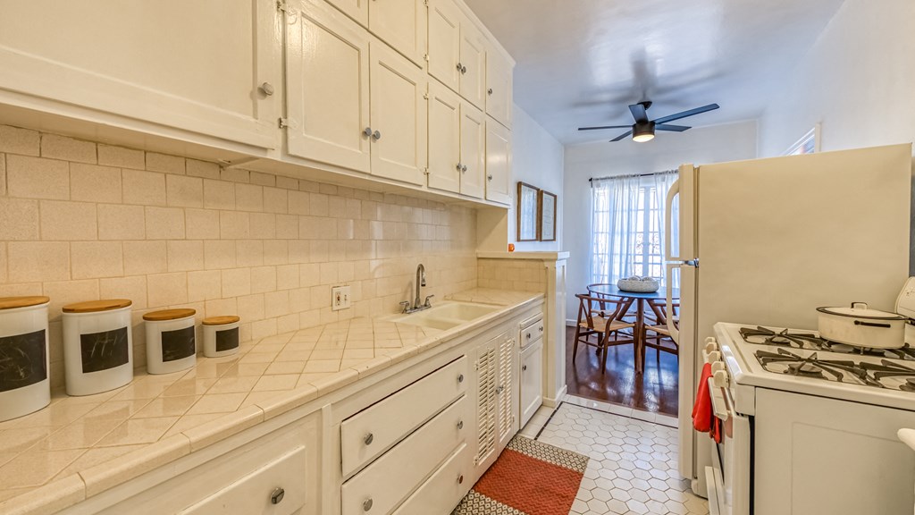 a kitchen with white cabinets and a stove and a refrigerator